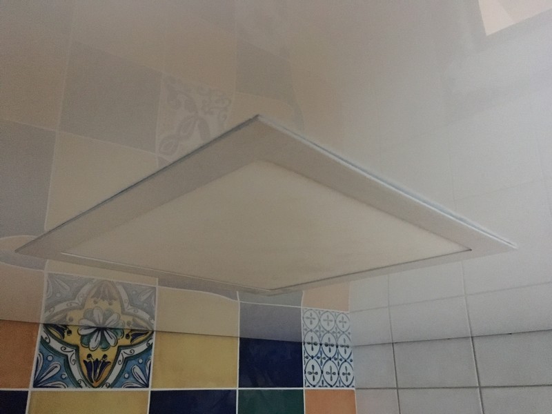 Белый лаковый натяжной потолок с квадратным светодиодным светильником фото.