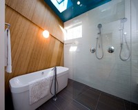 Просторная ванная с душевым отделением под бирюзовым лаковым потолком.