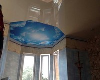 Двухуровневый натяжной потолок с лаковой фактурой внизу и матовой с фотопечатью вверху.