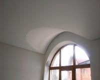 Вынужденная арка из натяжного потолка над окном продиктована уровнем потолка.