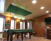 Замшевый натяжной потолок зеленого цвета в бильярдной под цвет сукна стола.