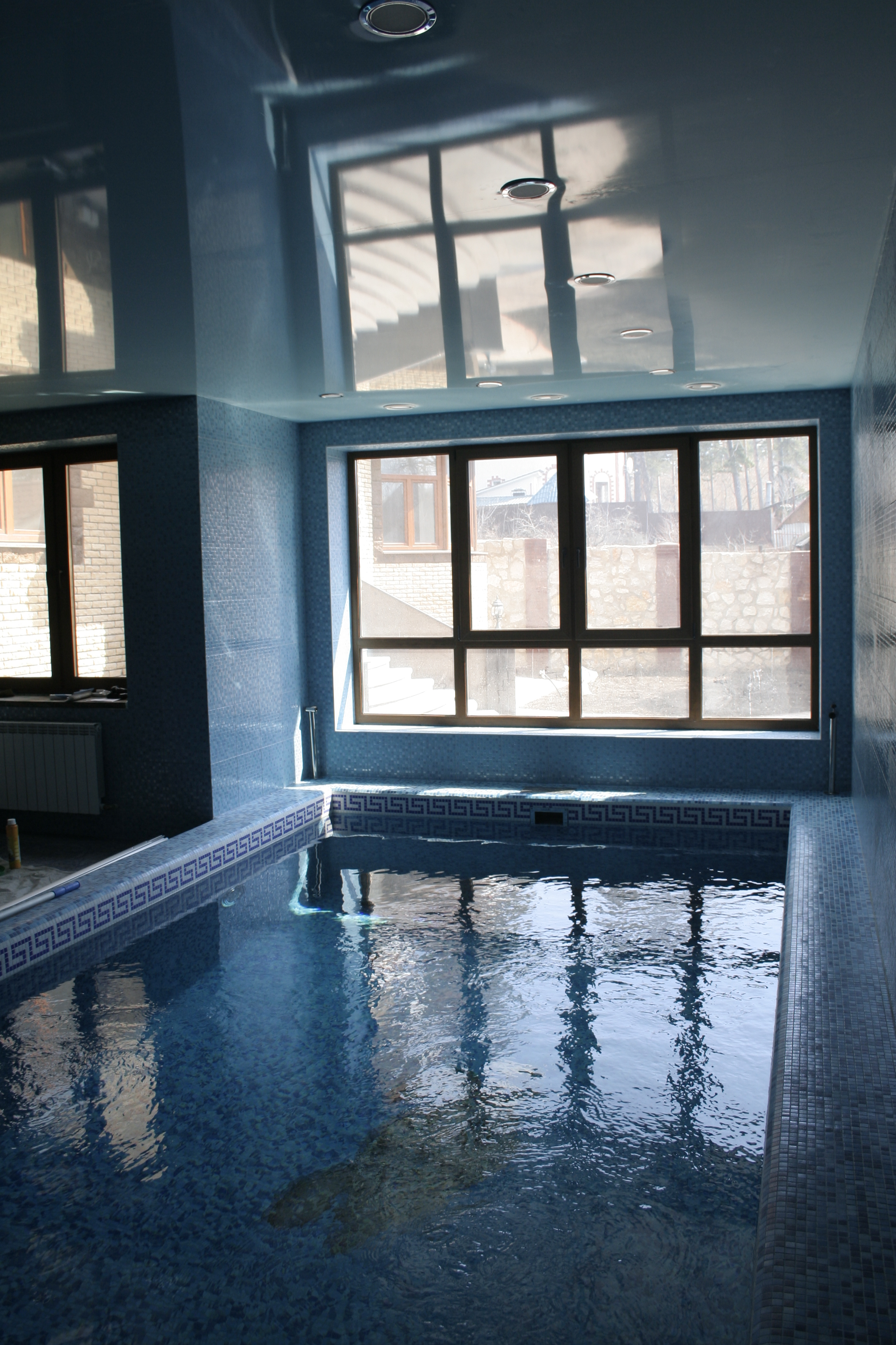 Голубой глянцевый натяжной потолок в бассейне фото.