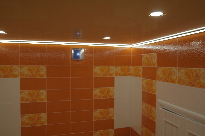 Контурная подсветка натяжного потолка лаковой фактуры оранжевого цвета.