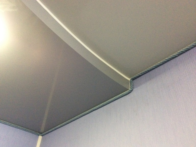 Двухуровневый натяжной потолок с серо-зеленым декоративным шнуром фото.