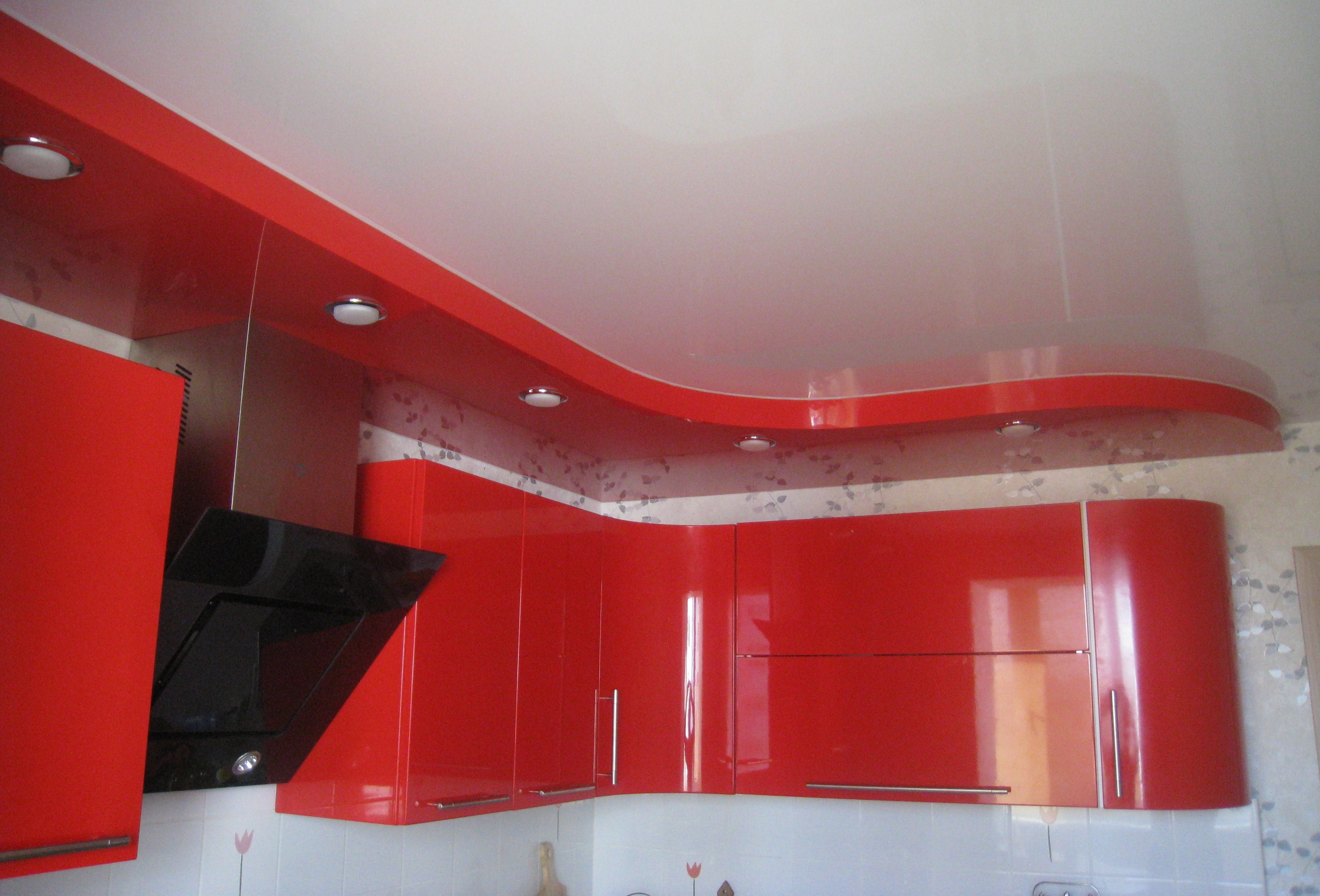 Красно-белый многоуровневый натяжной потолок на кухне.